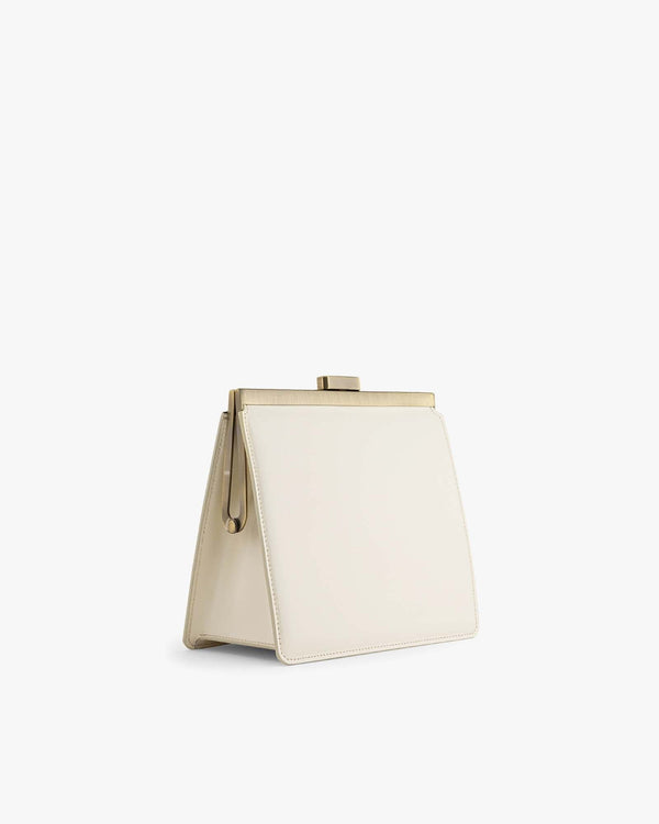Sac JEANNE Ivoire de profil, posé, fermoir métallique doré et anse amovible visibles