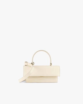 Sac THEA MINI ivoire, vue de face, posé, avec anse courte et bandoulière amovible détachée