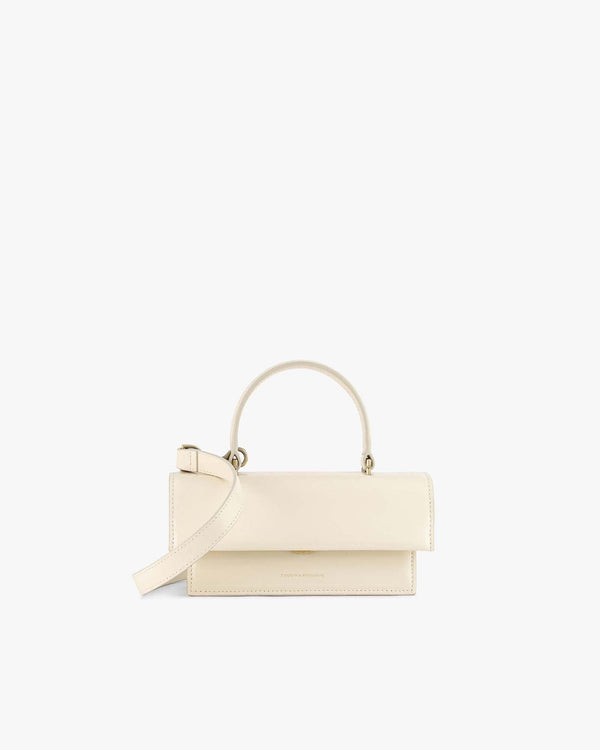 Sac THEA MINI ivoire, vue de face, posé, avec anse courte et bandoulière amovible détachée