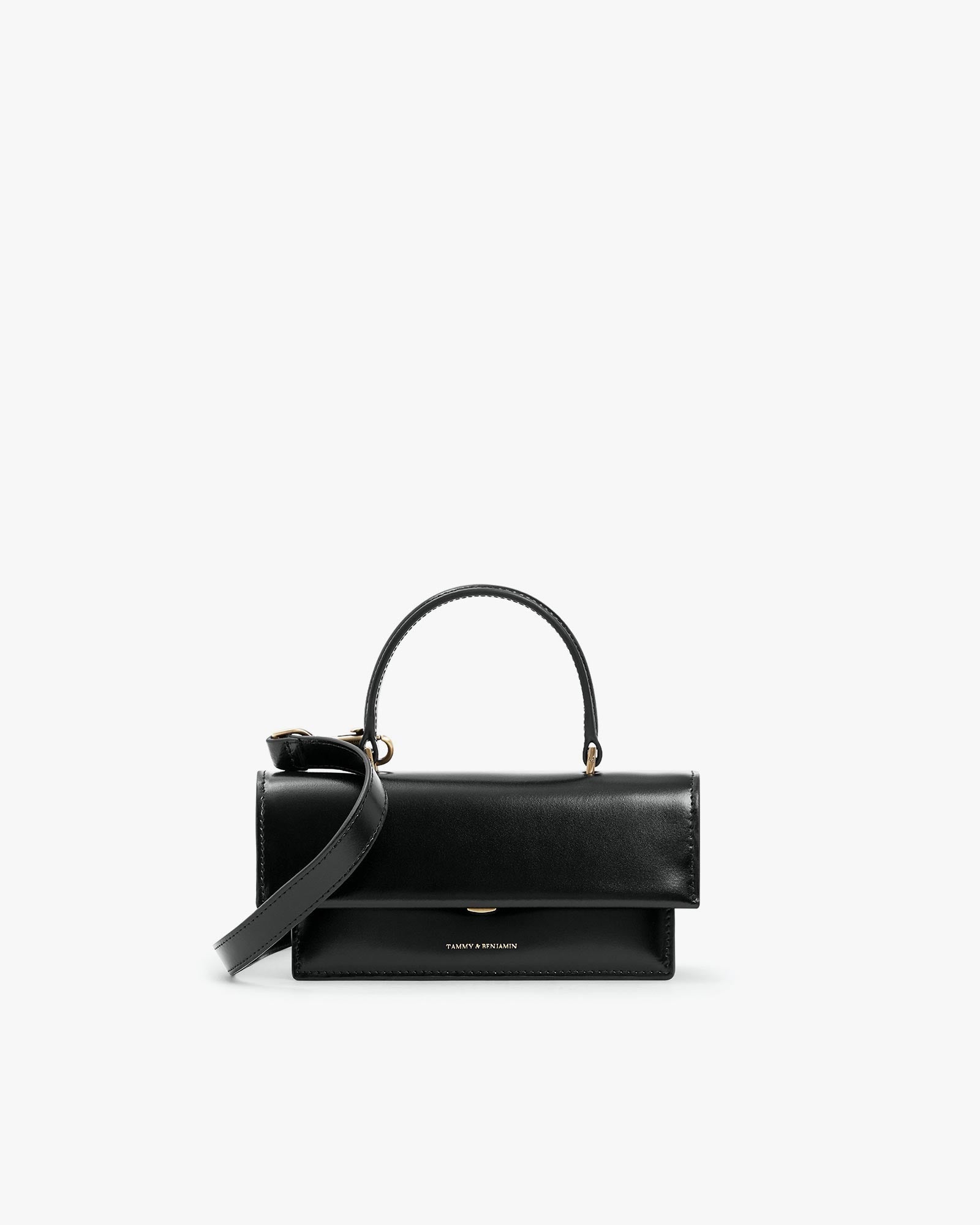 Sac THEA MINI noir de face, rabat fermé, anse courte, bandoulière détachée posée devant